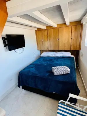 a bedroom with a blue bed and a tv at Loft con terraza y jacuzzi en el centro historico in Cartagena de Indias