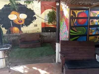 a building with paintings on the wall and two benches at Nahimara Champeta Hostel in Cartagena de Indias