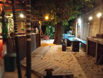 a patio with a table and a tree at night at Nahimara Champeta Hostel in Cartagena de Indias