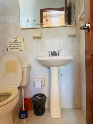 a bathroom with a sink and a toilet and a mirror at Paraiso Pie de la Popa in Cartagena de Indias