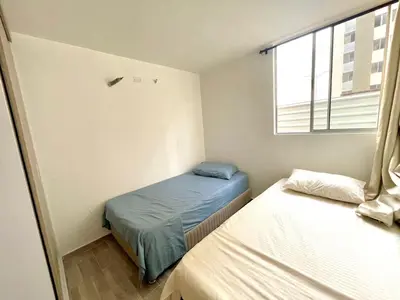 a small bedroom with two beds and a window at Ciudad Mallorquin in Puerto Colombia