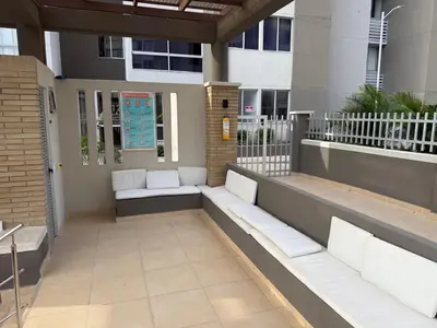 a patio with white benches in front of a building at Ciudad Mallorquin in Puerto Colombia