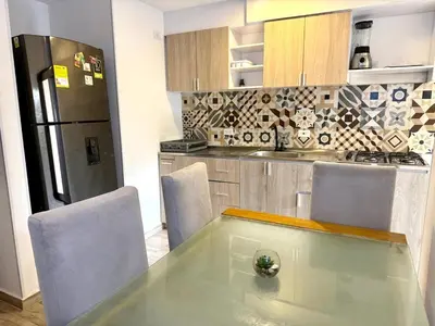 a kitchen with a glass table and a refrigerator at Ciudad Mallorquin in Puerto Colombia