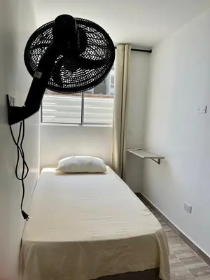 a room with a bed with a fan hanging over it at Ciudad Mallorquin in Puerto Colombia