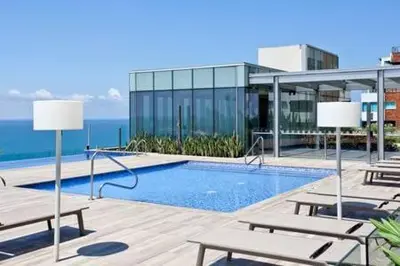 a swimming pool with benches and a building at Apartamentos en Edificio H2 Bocagrande Cerca al Mar in Cartagena de Indias