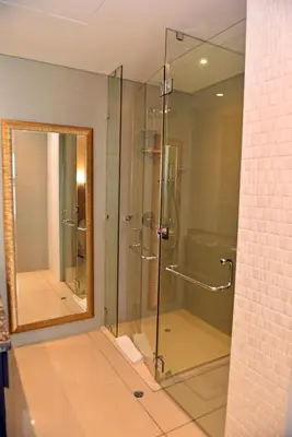 a glass shower in a bathroom with a mirror at Apartamentos en Edificio H2 Bocagrande Cerca al Mar in Cartagena de Indias