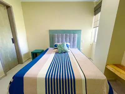 a bedroom with a large bed with a blue headboard at Magico Apartaemento Frente al Mar 4 Habitaciones E92 in Coveñas