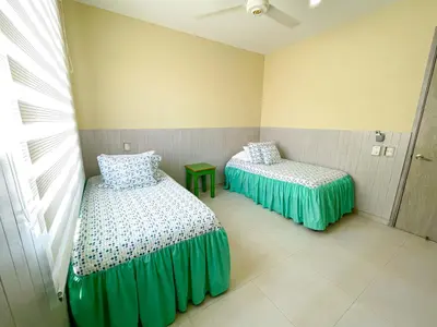 two beds in a room with green covers at Magico Apartaemento Frente al Mar 4 Habitaciones E92 in Coveñas