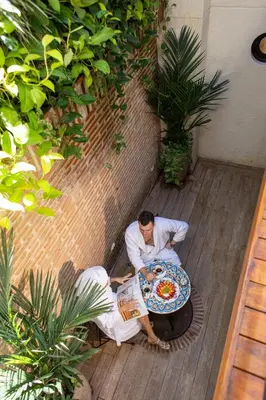 two men sitting at a table with a plate of food at Casa Santino Luxury Getsemaní-Cartagena in Cartagena de Indias