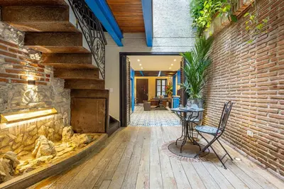a patio with a table and a brick wall at Casa Santino Luxury Getsemaní-Cartagena in Cartagena de Indias