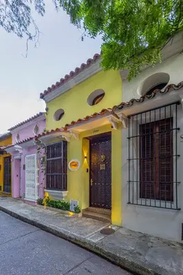 a yellow and pink house on a street at Casa Santino Luxury Getsemaní-Cartagena in Cartagena de Indias