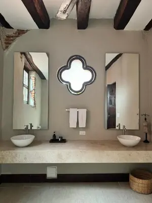 two sinks in a bathroom with two mirrors at Casa Estrella Colonial Mansion in Cartagena de Indias
