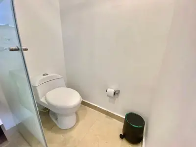 a bathroom with a toilet and a glass shower stall at Hermoso Aparta Suite en Crespo a 5 minutos caminando del aeropuerto primera línea Mar in Cartagena de Indias