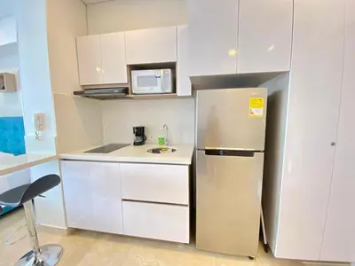 a small kitchen with a refrigerator and a microwave at Hermoso Aparta Suite en Crespo a 5 minutos caminando del aeropuerto primera línea Mar in Cartagena de Indias