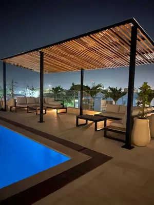 a pavilion with couches and a pool at night at Hermoso Aparta Suite en Crespo a 5 minutos caminando del aeropuerto primera línea Mar in Cartagena de Indias