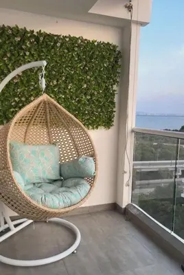 a hanging rattan chair on a balcony with a view of the ocean at Apartamento con salida privada a la playa en Morros, Cartagena in Cartagena de Indias