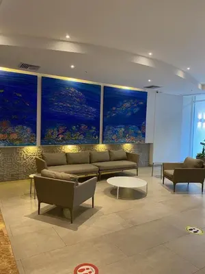 a living room with couches and paintings on the walls at Apartamento con salida privada a la playa en Morros, Cartagena in Cartagena de Indias
