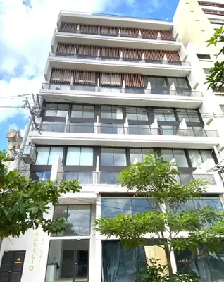 a tall white building with trees in front of it at Appartement neuf centre Cartagena la matuna in Cartagena de Indias