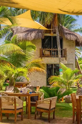 a restaurant with a table and chairs and a building at Palmarito Beach Hotel in Tierra Bomba