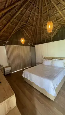 a bedroom with a large bed with a wooden floor at Palmarito Beach Hotel in Tierra Bomba