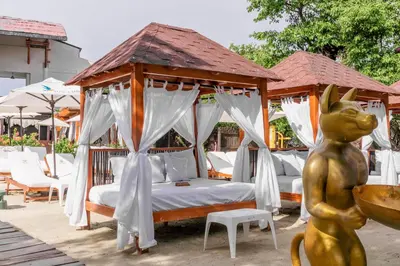 a gazebo with a bed and a statue next to it at Pao Pao Cartagena in Isla Grande