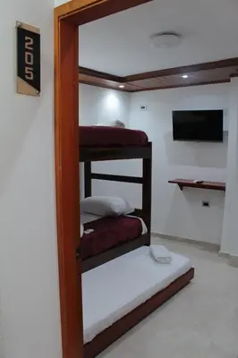 a room with two bunk beds and a flat screen tv at Hospedaje san gabriel in Barranquilla