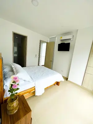 a bedroom with a bed and a vase with flowers on a table at Paraíso frente al mar in Coveñas
