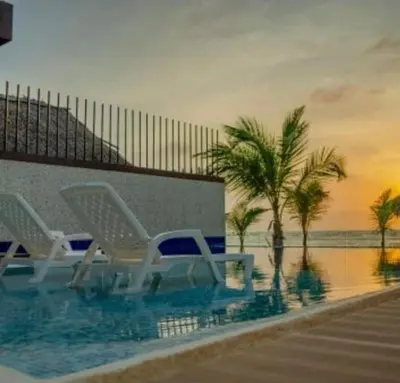 two chairs sitting in a swimming pool near the ocean at Paraíso frente al mar in Coveñas