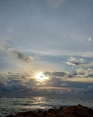 a cloudy sky over the ocean with the sun setting at Paraíso frente al mar in Coveñas