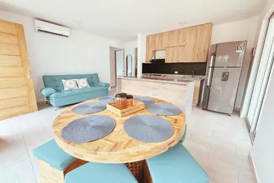 a kitchen with a wooden table and blue chairs at Cabaña 5 Playa Piso 1- Palmar De Los Vientos-San Bernardo del Viento in Pueblo Coco