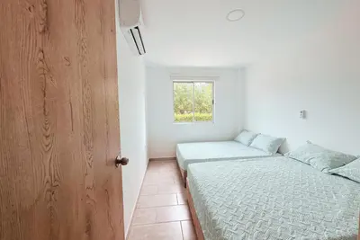 a bedroom with two beds and a window at Cabaña 5 Playa Piso 1- Palmar De Los Vientos-San Bernardo del Viento in Pueblo Coco