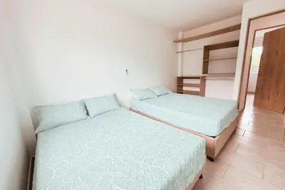 a bedroom with two beds and a closet at Cabaña 5 Playa Piso 1- Palmar De Los Vientos-San Bernardo del Viento in Pueblo Coco