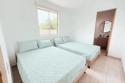 a bedroom with two beds and a mirror at Cabaña 5 Playa Piso 1- Palmar De Los Vientos-San Bernardo del Viento in Pueblo Coco
