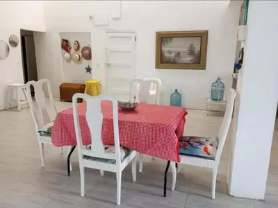 a dining room with a red table and white chairs at San Jose de los Acuarios in San Antero