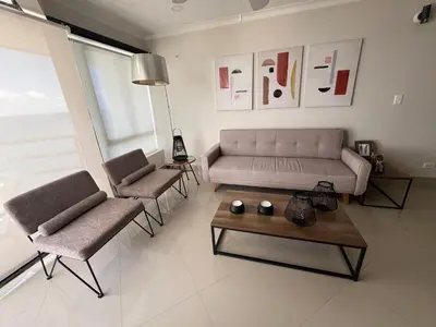 a living room with a couch and two chairs and a table at Sleep by the Caribbean in Cartagena de Indias