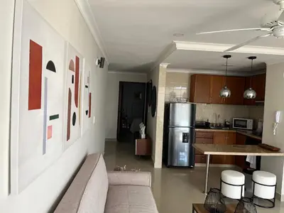 a living room with a couch and a kitchen at Sleep by the Caribbean in Cartagena de Indias