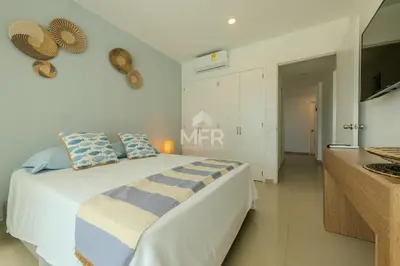 a white bedroom with a bed and a kitchen at Morros Epic Beachfront Apartment in Cartagena de Indias