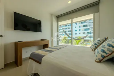 a bedroom with a bed and a large window at Morros Epic Beachfront Apartment in Cartagena de Indias