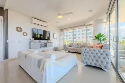 a white living room with two beds and a couch at Morros Epic Beachfront Apartment in Cartagena de Indias