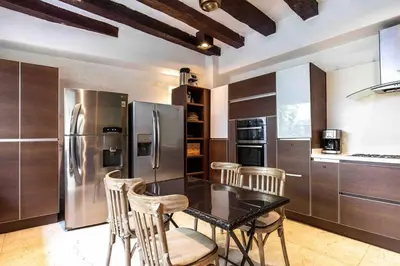 a kitchen with a black table and a refrigerator at Casa Gastelbondo in Cartagena de Indias