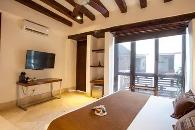 a bedroom with a bed and a large window with a tv at Casa Gastelbondo in Cartagena de Indias