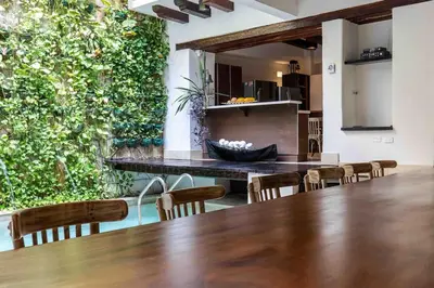 a dining room with a table and chairs and a green wall at Casa Gastelbondo in Cartagena de Indias