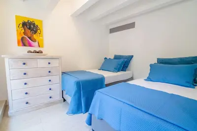 a bedroom with two beds and a dresser at Santo Domingo - Centro Histórico in Cartagena de Indias