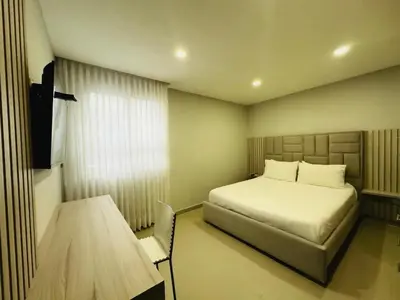 a bedroom with a bed and a table in it at Hotel OR Suite in Barranquilla