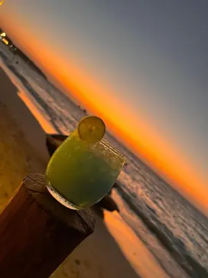 a green drink sitting on top of the beach at Roma apartamento in Playa Blanca