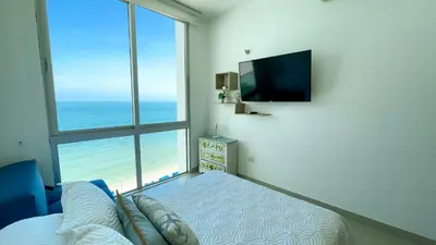 a bedroom with a bed and a large window with the ocean at Magico Apartamento Frente al Mar 4 Habitaciones BM63 in Coveñas