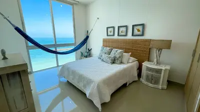 a bedroom with a bed with a view of the ocean at Magico Apartamento Frente al Mar 4 Habitaciones BM63 in Coveñas