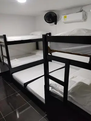 two bunk beds in a dorm room with white sheets at Apartamento Coveñas Castillo Club Cabaña 5 in Coveñas