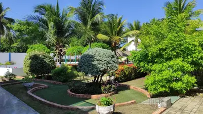 a garden with palm trees and bushes and plants at Apartamento Coveñas Castillo Club Cabaña 5 in Coveñas