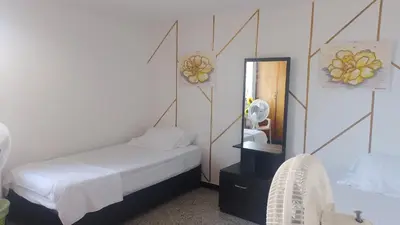 a small bedroom with a bed and a mirror at Confortable habitación en apartamento familiar en el Prado in Barranquilla